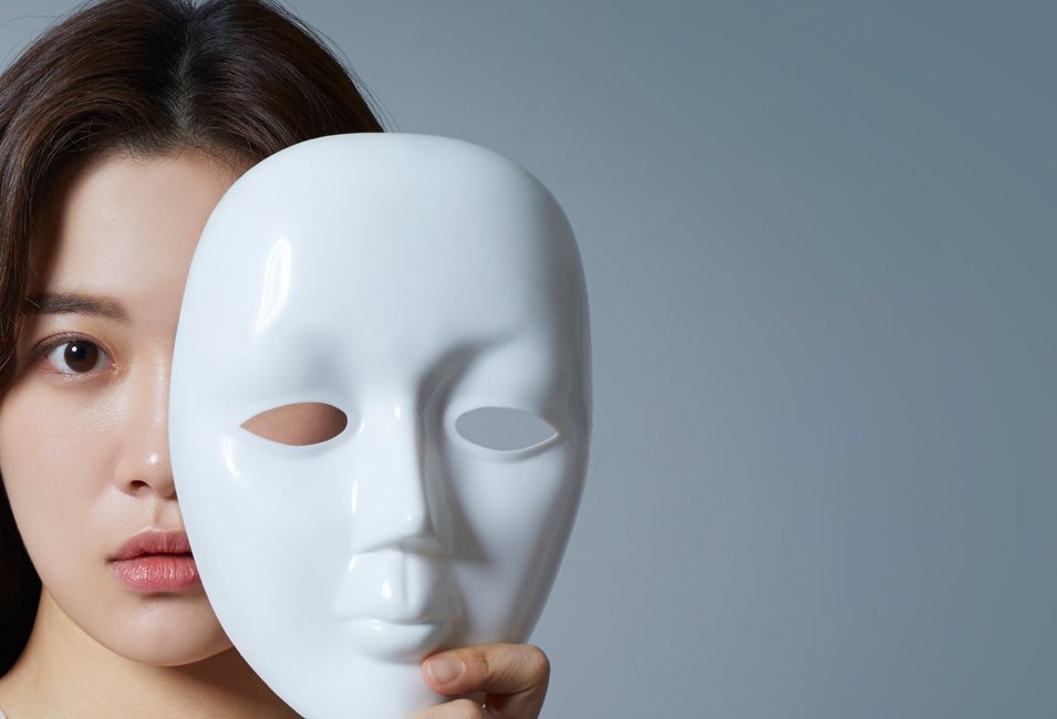 흰 가면으로 얼굴 반쪽을 가린 단발 여성 모델